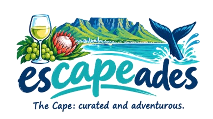 escapeades, the Cape: curated and adventurous. Table Mountain above the bay, with a glass of white wine, grapes, a protea and a whale's tail.