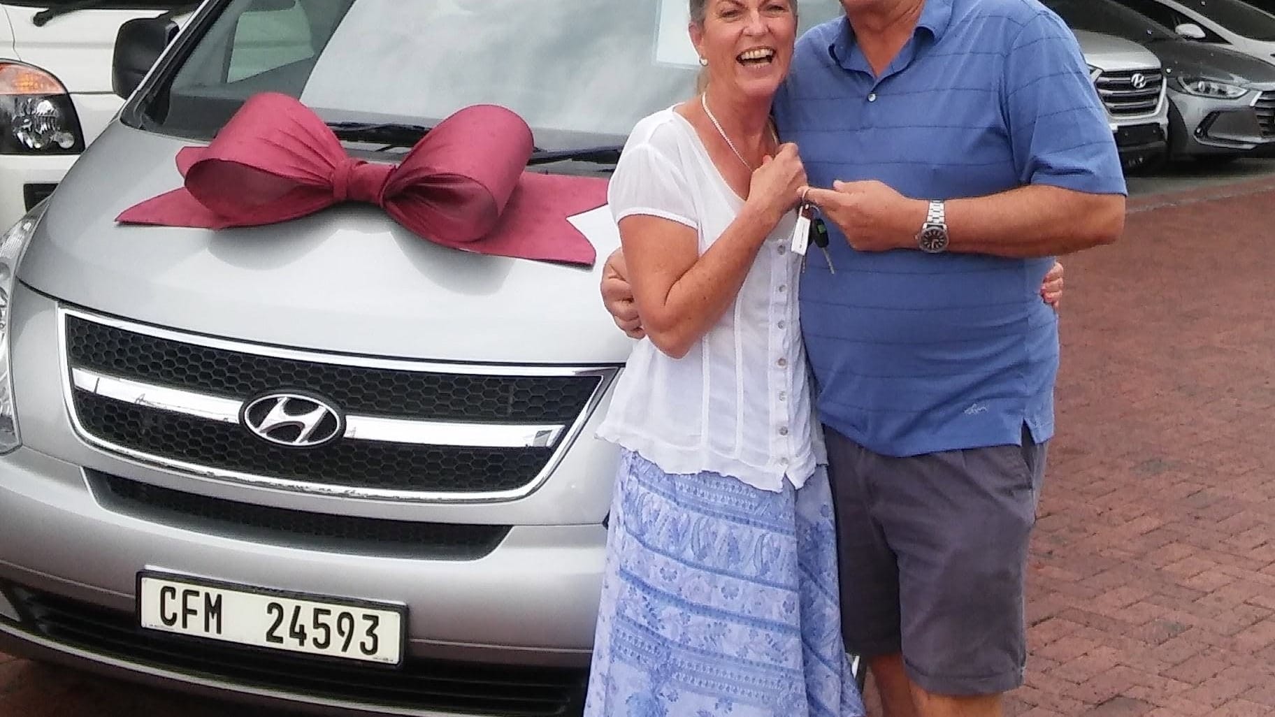 Angie and Fred collecting the tour vehicle, a ribbon still tied across the bonnet