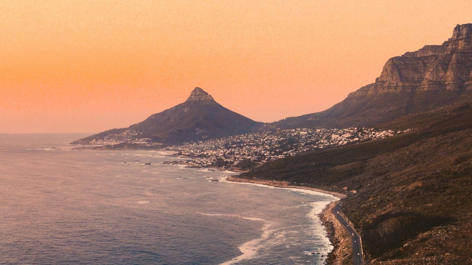 The Atlantic seaboard road seen from the air at sunset, with Lion's Head beyond