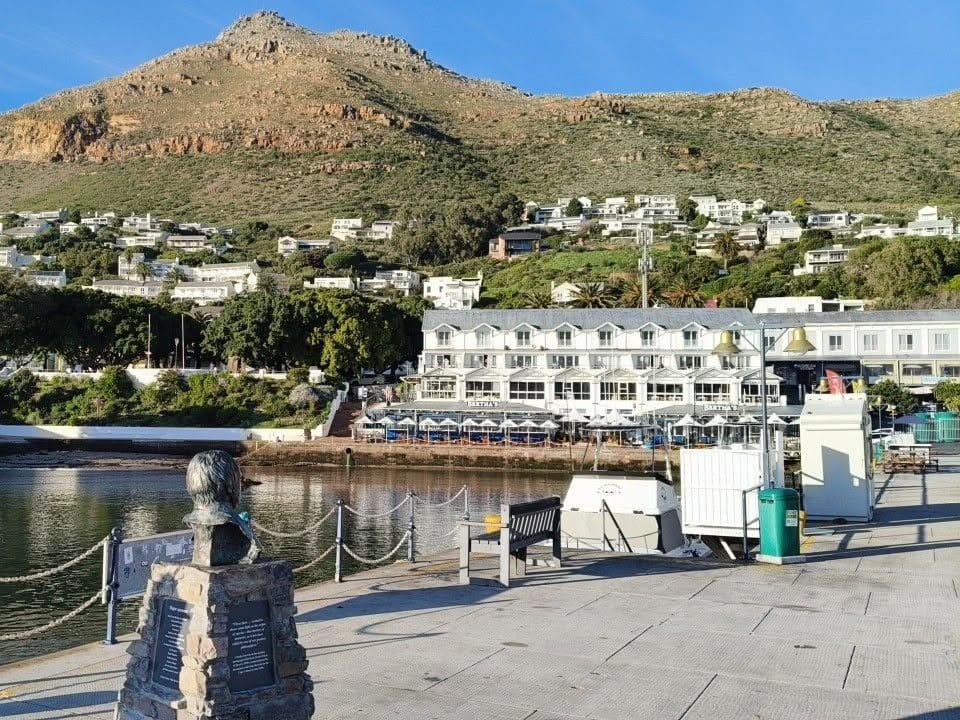 Simon's Town harbour with the Just Nuisance statue on the quay and the mountain behind