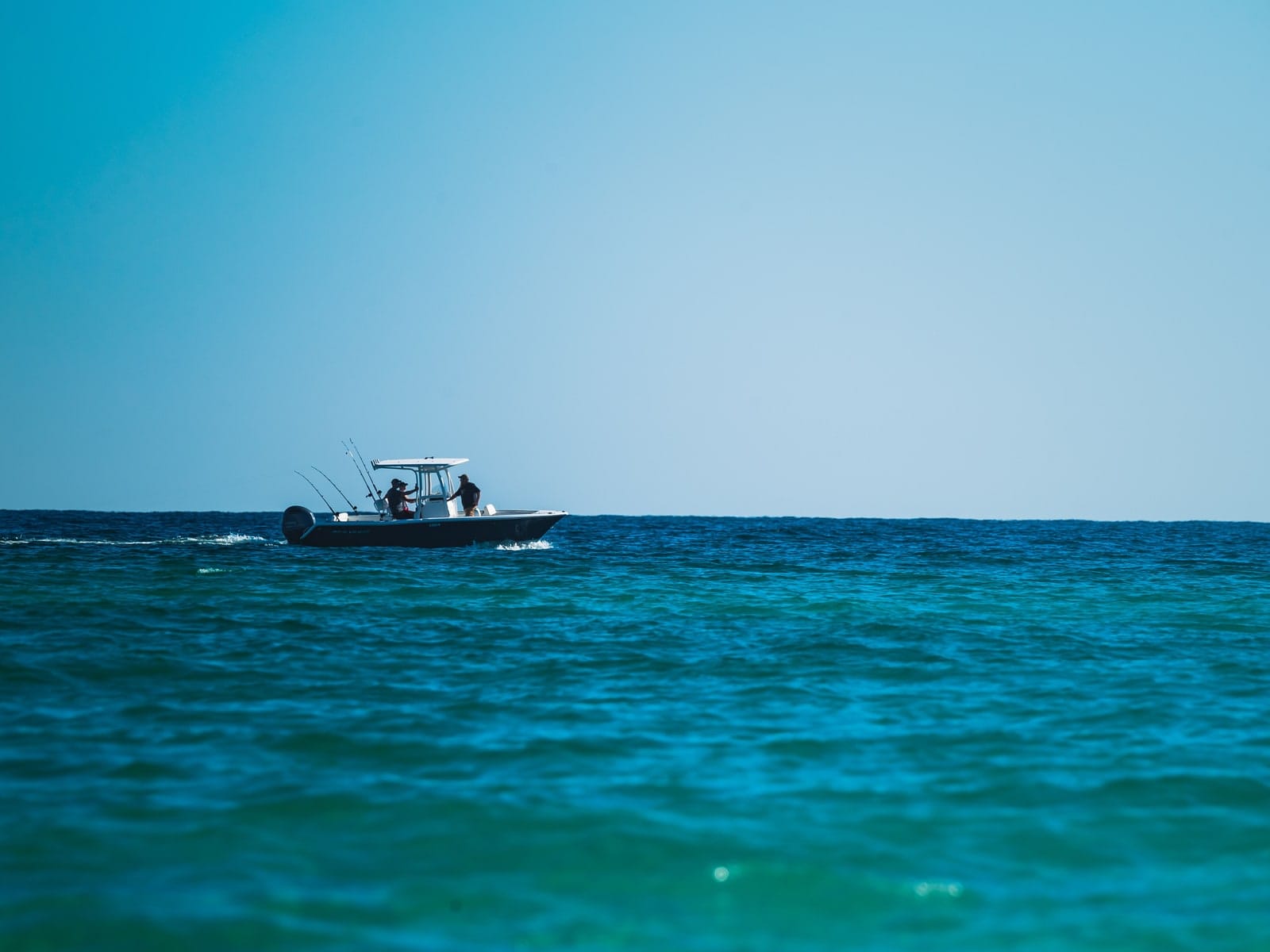 Fishing rods set in the transom of a charter boat with open ocean behind