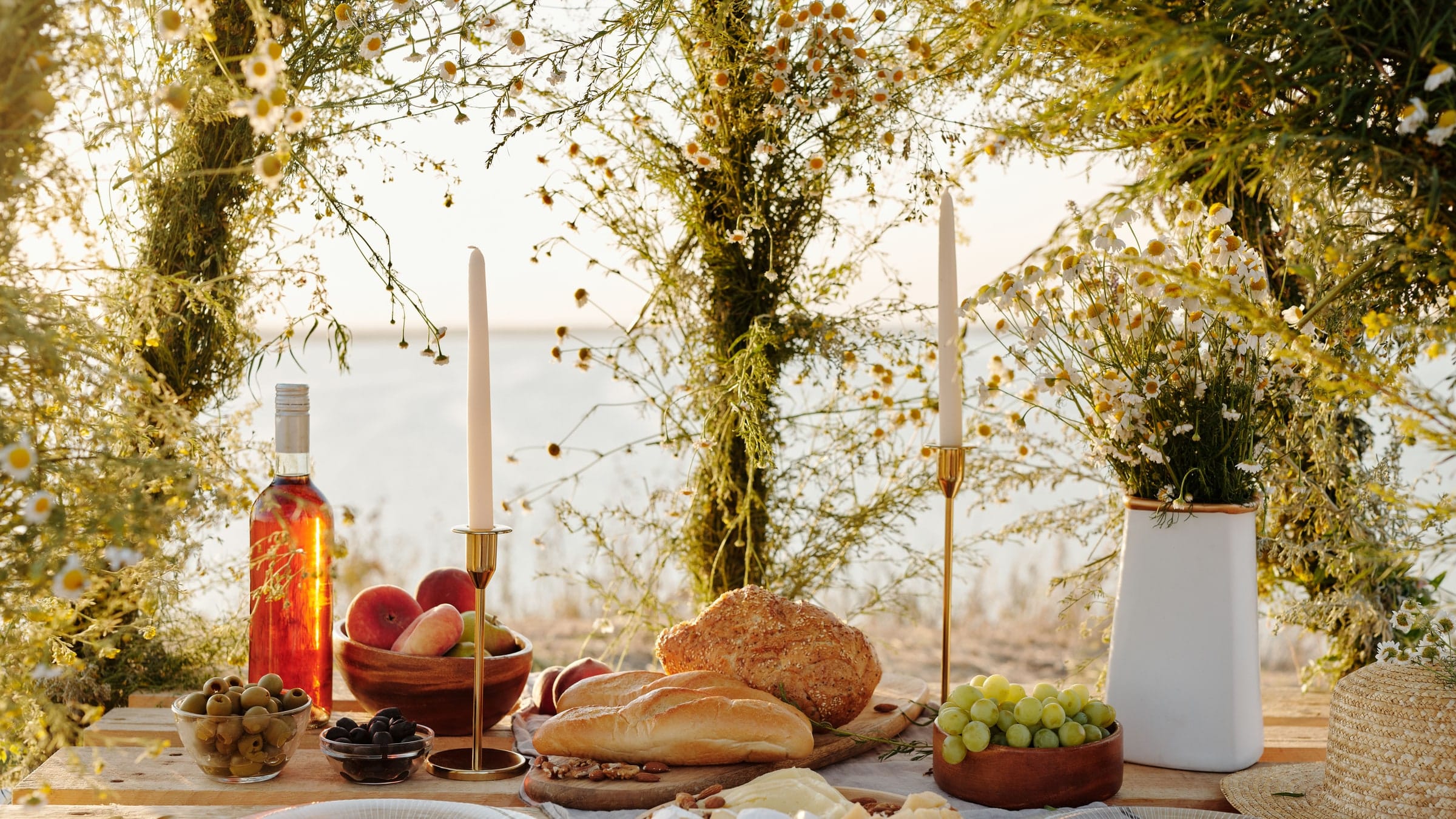 A table laid for two on a terrace above vineyards as the light fades