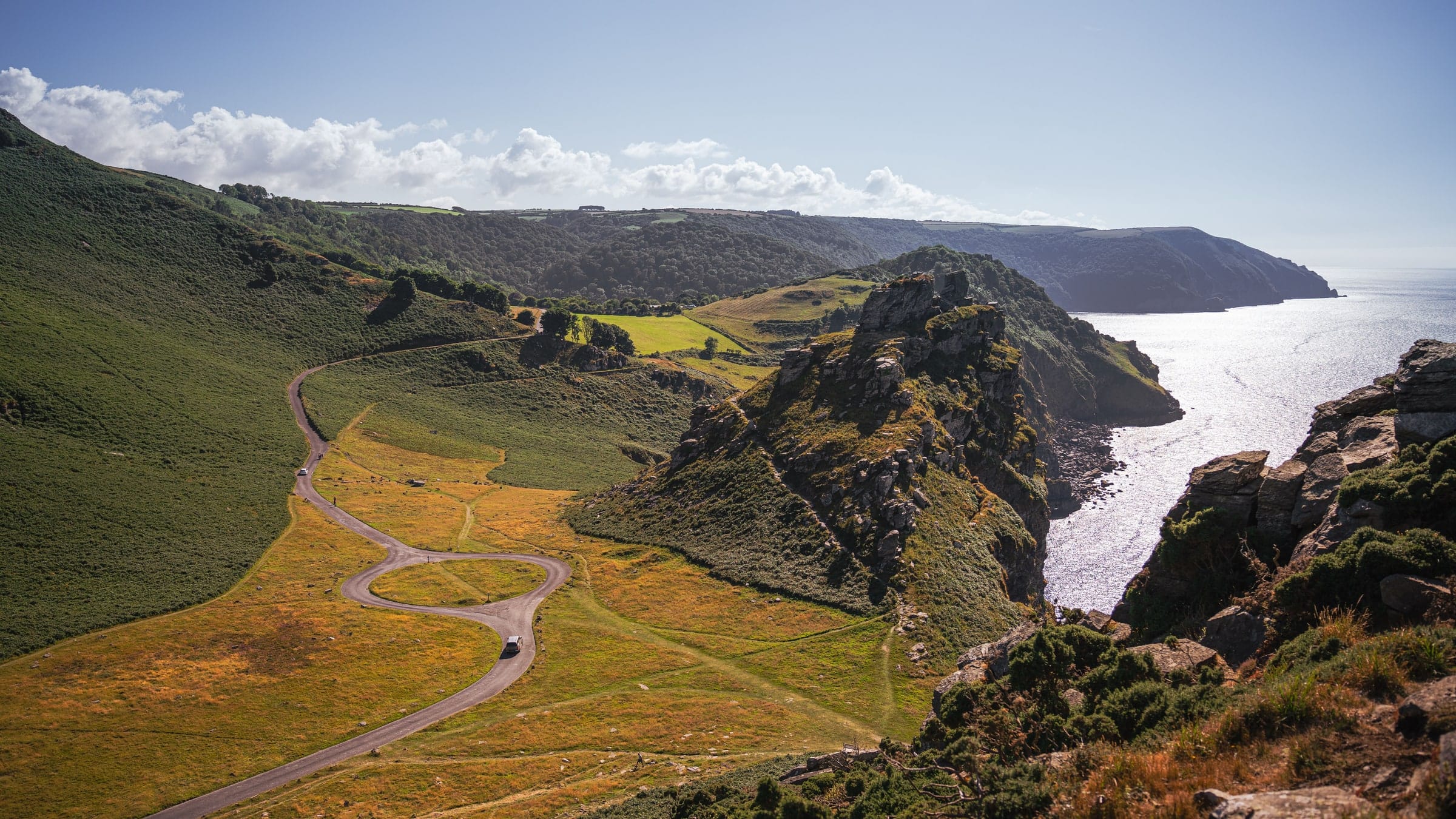 The peninsula coast road curving between cliff and sea in early morning light