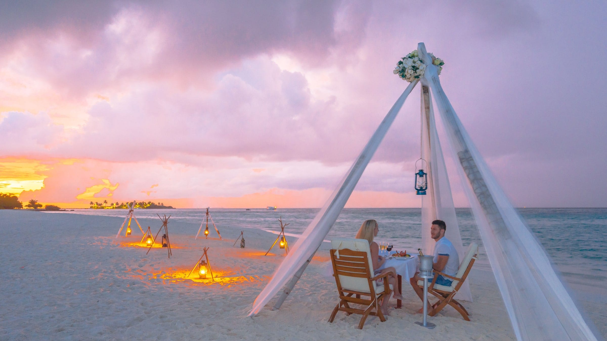 A table set for two on a terrace above the Atlantic as the sun goes down